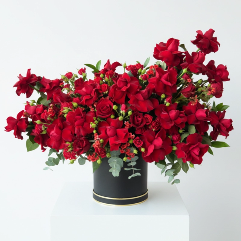 Grand arrangement of red roses and baby roses in a luxury black cylindrical box, perfect for romantic delivery in the UAE by onlineflowershop.ae.